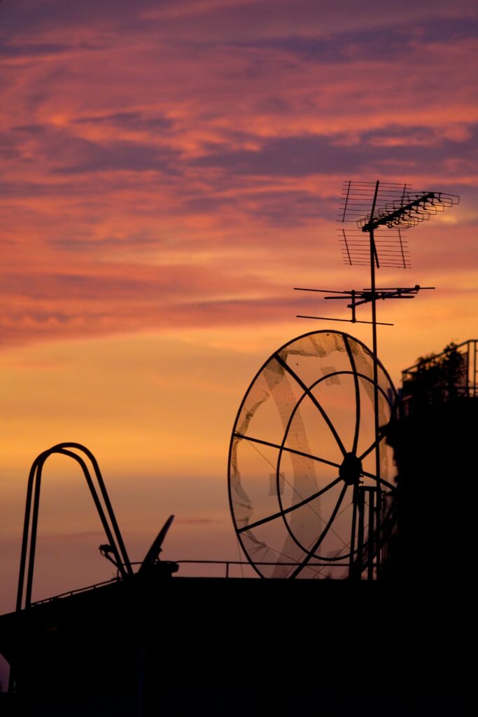 radarsystem Silhouette of satellite dishes and antennas against a colorful sunset sky. Perfect for technology themes.